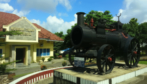 Eksterior Museum Timah Indonesia di Pangkalpinang, menampilkan bangunan museum dan lokomotif tua di halaman depan.